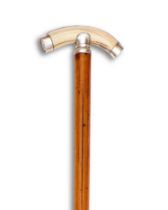 A WALKING CANE WITH BOAR TUSK AND 1943 SIX PENCE MOUNTED HANDLE