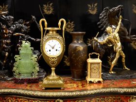 AN EARLY 19TH CENTURY EMPIRE PERIOD PATINATED AND GILT BRONZE MANTEL CLOCK