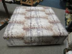 A LARGE UPHOLSTERED COFFEE TABLE