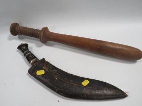 A KUKRI TOGETHER WITH A LARGE WOODEN TRUNCHEON