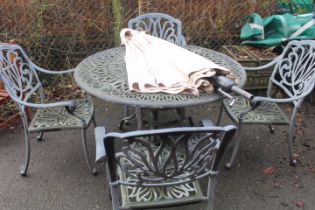 A CAST GARDEN PATIO TABLE WITH FOUR CHAIRS AND PARASOL