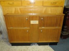 A VINTAGE TEAK AUSTIN FITTED TRAVELLING DRINKS CABINET, having four compartments with assorted