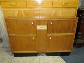 A VINTAGE TEAK AUSTIN FITTED TRAVELLING DRINKS CABINET, having four compartments with assorted