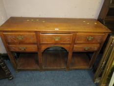 AN OAK SIDEBOARD WITH CARVED DRAWERS