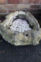 A CONCRETE BIRD BATH DEPICTING AN OTTER ON LOGS