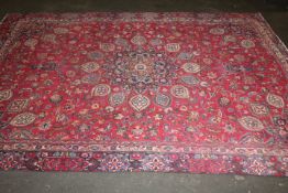 A LARGE EASTERN WOOLLEN RUG IN MAINLY RED AND BLACK PATTERN 362 X 269 CM