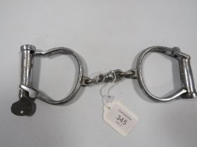A SET OF VINTAGE HANDCUFFS WITH KEY