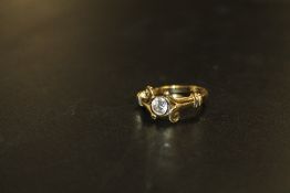 A HALLMARKED 18 CARAT GOLD HALF CARAT DIAMOND RING, in an unusual split swirl band setting, the