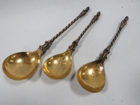 THREE ANTIQUE WHITE METAL SPOONS WITH GILT BOWLS