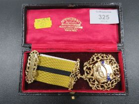 A HALLMARKED DECORATIVE SILVER GILT JEWEL WITH RIBBON