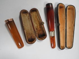 TWO CASED AMBER STYLE CHEROOT HOLDERS TO INCLUDE A HALLMARKED GOLD BANDED EXAMPLE