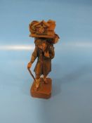 A VINTAGE HAND CARVED WOODEN FIGURE OF A TRAVELLING CLOCK SELLER