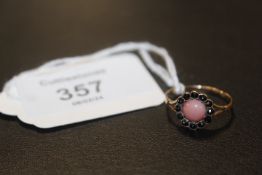 A CORAL AND GARNET DRESS RING ON YELLOW METAL WITH CONTINENTAL MARKS approx weight 1.4g