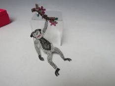 A LARGE BUTLER & WILSON ARTICULATED BROOCH DEPICTING A MONKEY SWINGING FROM A BRANCH, APPROX DROP 18