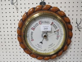 A CIRCULAR OAK WALL MOUNTED BAROMETER