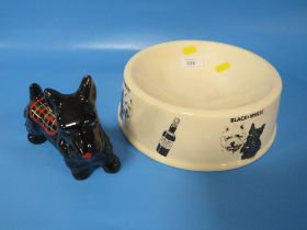 A BLACK AND WHITE WHISKY DOG BOWL TOGETHER WITH A MODEL OF A BLACK SCOTTIE DOG