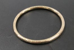 AN ANTIQUE ENGRAVED BANGLE MARKED ROLLED GOLD