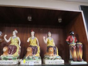 THREE REPRODUCTION STAFFORDSHIRE STYLE FIGURES OF BRITTANIA TOGETHER WITH A MAN PLAYING DRUMS ALL