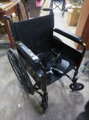 A FOLD AWAY PUSH WHEELCHAIR WITH SOLID TYRES AND HANDRAIL