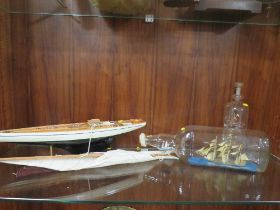 A VINTAGE MODEL OF A YACHT ON STAND TOGETHER WITH TWO SHIPS IN A BOTTLE