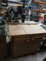 A RYOBI OVERHEAD RADIAL ARM SAW AND BENCH WITH STORAGE