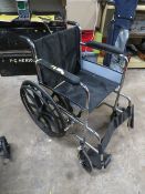 A FOLD AWAY CHROME BUDDY WHEELCHAIR WITH SOLID TYRES AND HAND RAILS