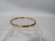 AN ANTIQUE ENGRAVED BANGLE MARKED ROLLED GOLD