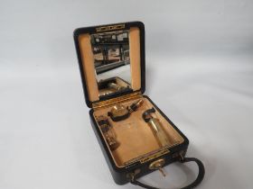 A SMALL TRAVELLING VANITY CASE WITH HALLMARKED SILVER GILT ACCESSORIES, complete with a base metal