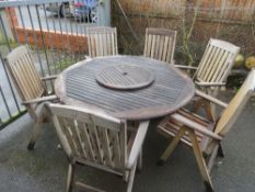 A LARGE HARDWOOD GARDEN TABLE AND SIX RECLINING FOLD AWAY CHAIRS