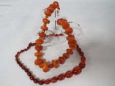 AN UNUSUAL VINTAGE AMBER BEAD NECKLACE, the chunky disc shaped amber bead interspersed with small