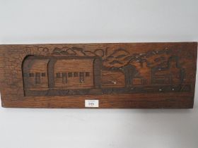A VINTAGE CARVED WOOD PANEL DEPICTING A STEAM ENGINE AND CARRIAGES EMERGING FROM A TUNNEL