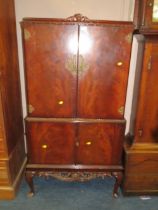 A MAHOGANY CARVED DRINKS CABINET ON CABRIOLE LEGS