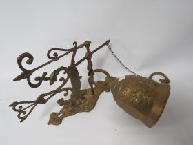 A VINTAGE GILT METAL WALL MOUNTED BRASS BELL