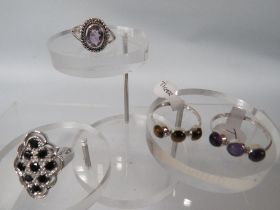 FOUR DECORATIVE SILVER DRESS RINGS