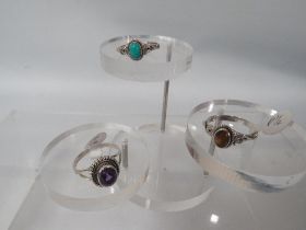 THREE SILVER DECORATIVE DRESS RINGS TO INCLUDE A TIGER EYE EXAMPLE