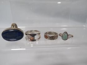 FOUR DECORATIVE SILVER DRESS RINGS TO INCLUDE A SPILT STYLE EXAMPLE