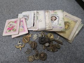 A SELECTION OF ANTIQUE GREETING CARDS TOGETHER WITH A SMALL QUANTITY OF MILITARY CAP BADGES