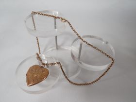 AN ANTIQUE LOCKET AND CHAIN - LOCKET MARKED 9CT BACK AND FRONT