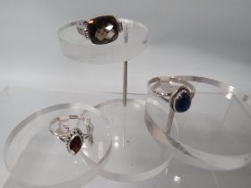 THREE DECORATIVE SILVER DRESS RINGS TO INCLUDE A SMOKY QUARTZ STYLE EXAMPLE