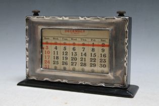 A HALLMARKED SILVER FRAMED DESK CALENDAR WITH UNUSUAL MANUAL WIND RED BAND DATE CALENDAR -