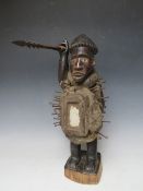 A KONGO POWER FIGURE BRANDISHING AN IRON SPEAR WITH INSET GLASS EYES AND A PANEL TO HIS ABDOMEN, H