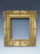 A 19TH CENTURY DECORATIVE GOLD SWEPT FRAME, frame W 6.5 cm, rebate 23 x 20 cm
