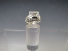 A HALLMARKED HANDMADE 18 CARAT WHITE GOLD DIAMOND RING, set with a central Princess cut diamond of