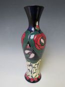 A MOORCROFT POTTERY BALUSTER VASE, with tubelined floral design on a dark blue ground, marks and