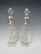 A PAIR OF SILVER COLLARED GLASS DECANTERS - BIRMINGHAM 1929, H 25 cm