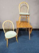 AN ERCOL LIGHT ELM DROPLEAF TABLE, together with two hoop back chairs