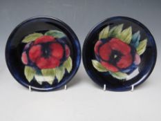 A PAIR OF MOORCROFT PANSY PATTERN DISHES, with tubelined decoration, impressed marks and signed with
