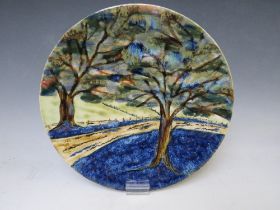 A COBRIDGE CIRCULAR CHARGER BY ANITA HARRIS, decorated with trees, impressed factory mark, limited