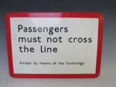 A VINTAGE 'PASSENGERS MUST NOT CROSS THE LINE EXCEPT BY MEANS OF THE FOOTBRIDGE' ENAMEL SIGN, 32.5 x