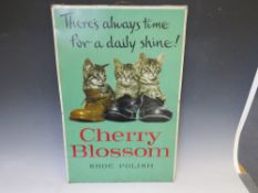 A VINTAGE 'CHERRY BLOSSOM SHOE POLISH' ADVERTISING TIN SIGN, mounted on a board, 67.5 x 45 cm